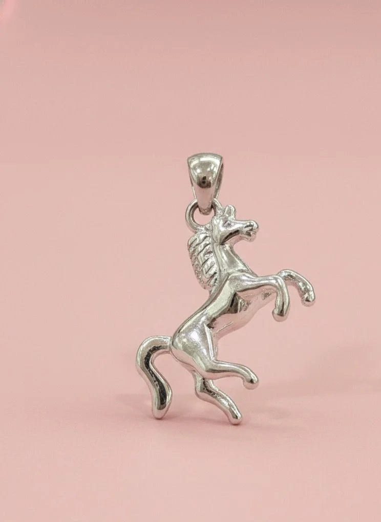 Silver horse pendant on a pink background