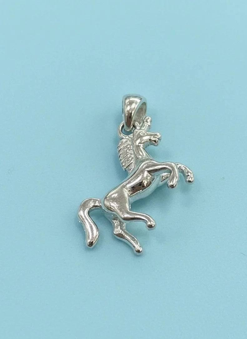 Silver horse pendant on a light blue background