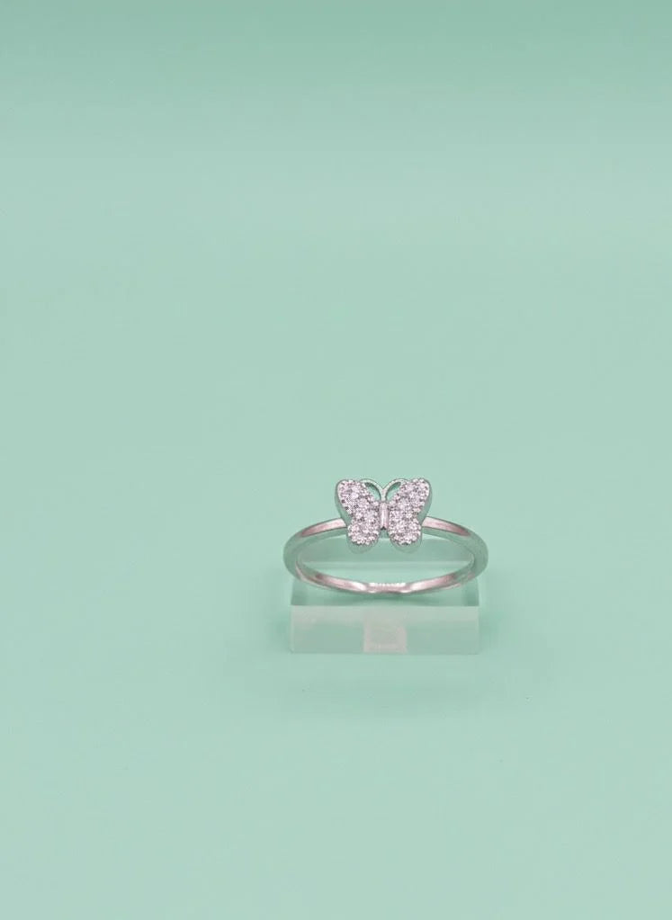 Silver butterfly ring on a light green background