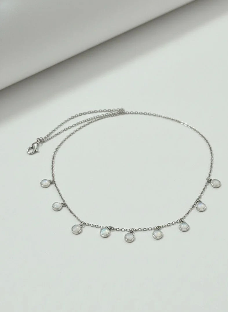 Silver necklace with pearl-like beads on a light gray background