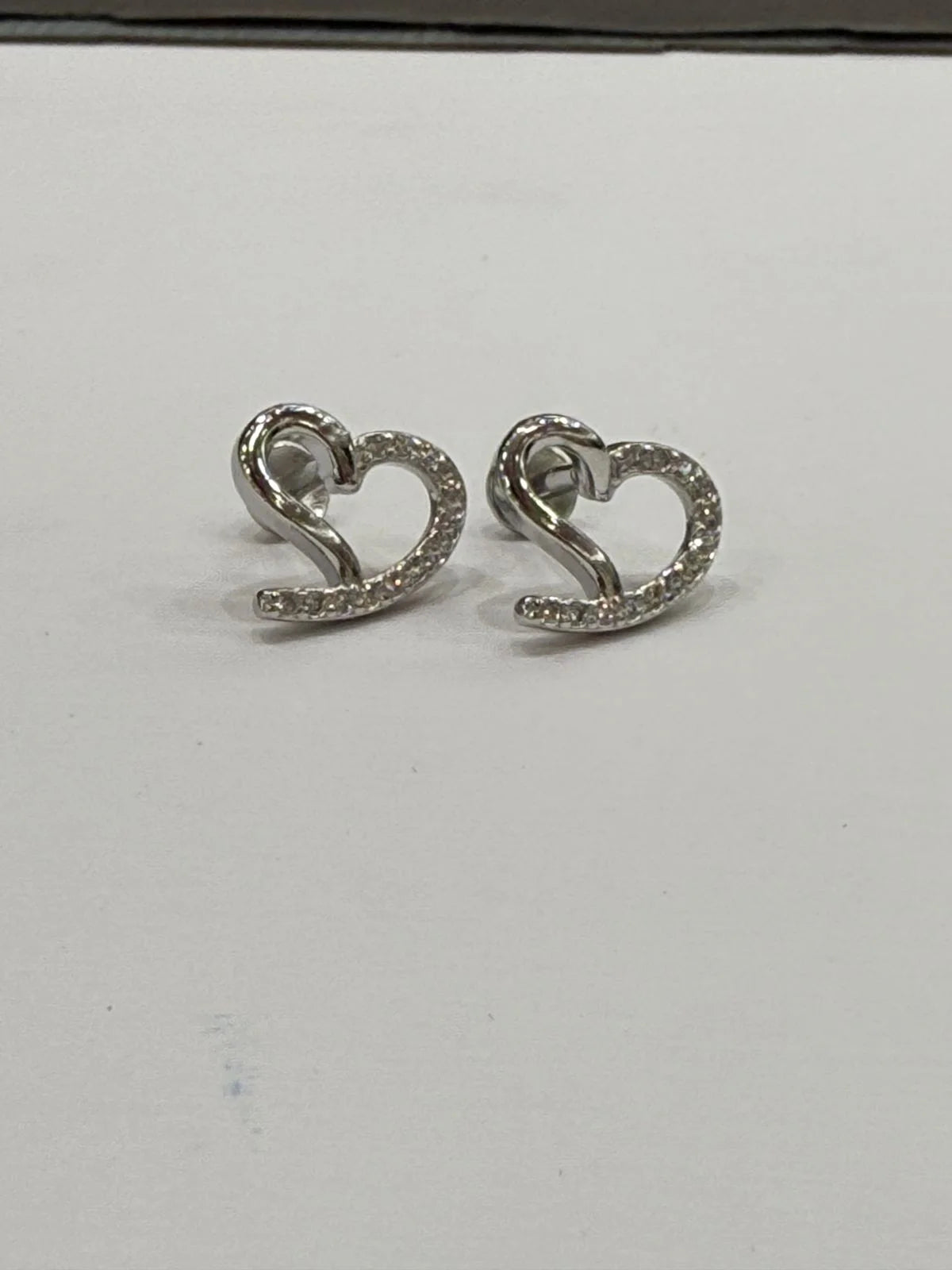 Heart-shaped silver earrings on a white background