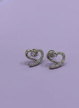 Heart-shaped earrings with sparkling stones on a light purple background