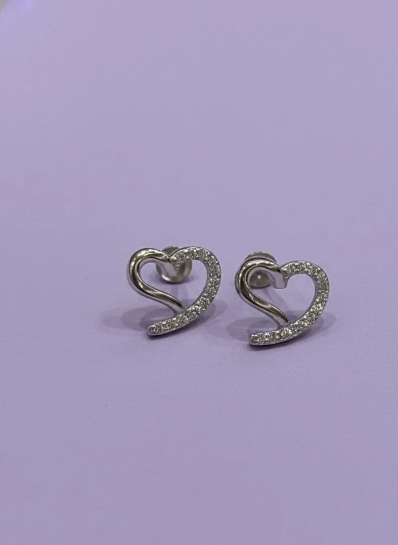 Heart-shaped earrings with sparkling stones on a light purple background