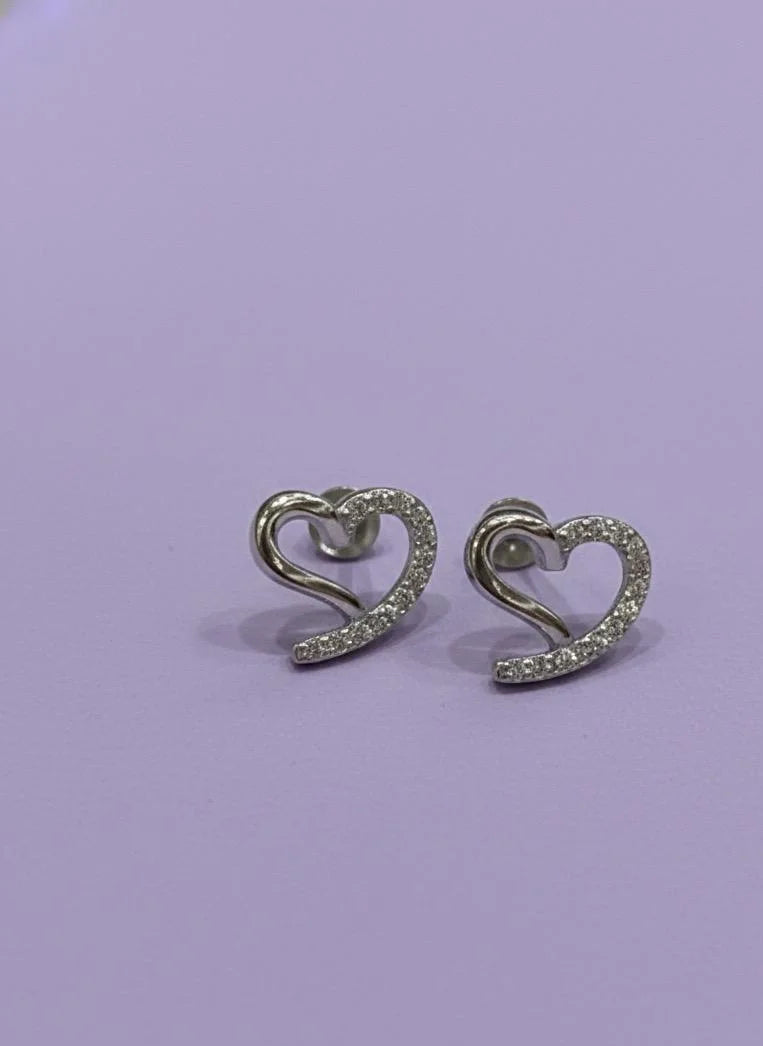 Heart-shaped earrings with sparkling stones on a light purple background
