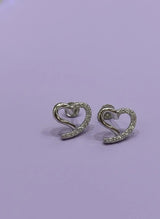 Heart-shaped earrings with sparkling stones on a light purple background