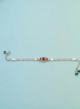 Silver bracelet with gemstones on a light blue background