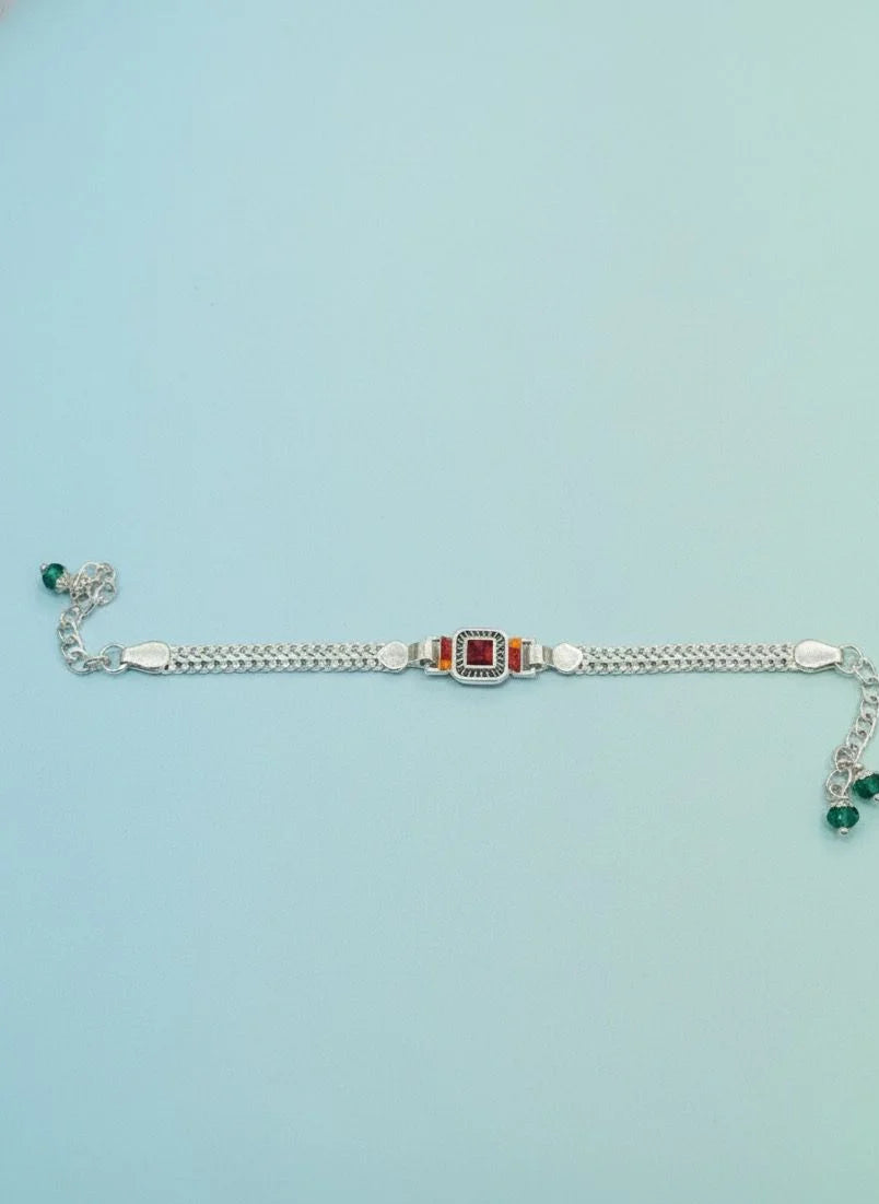 Silver bracelet with gemstones on a light blue background