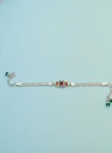 Silver bracelet with gemstones on a light blue background
