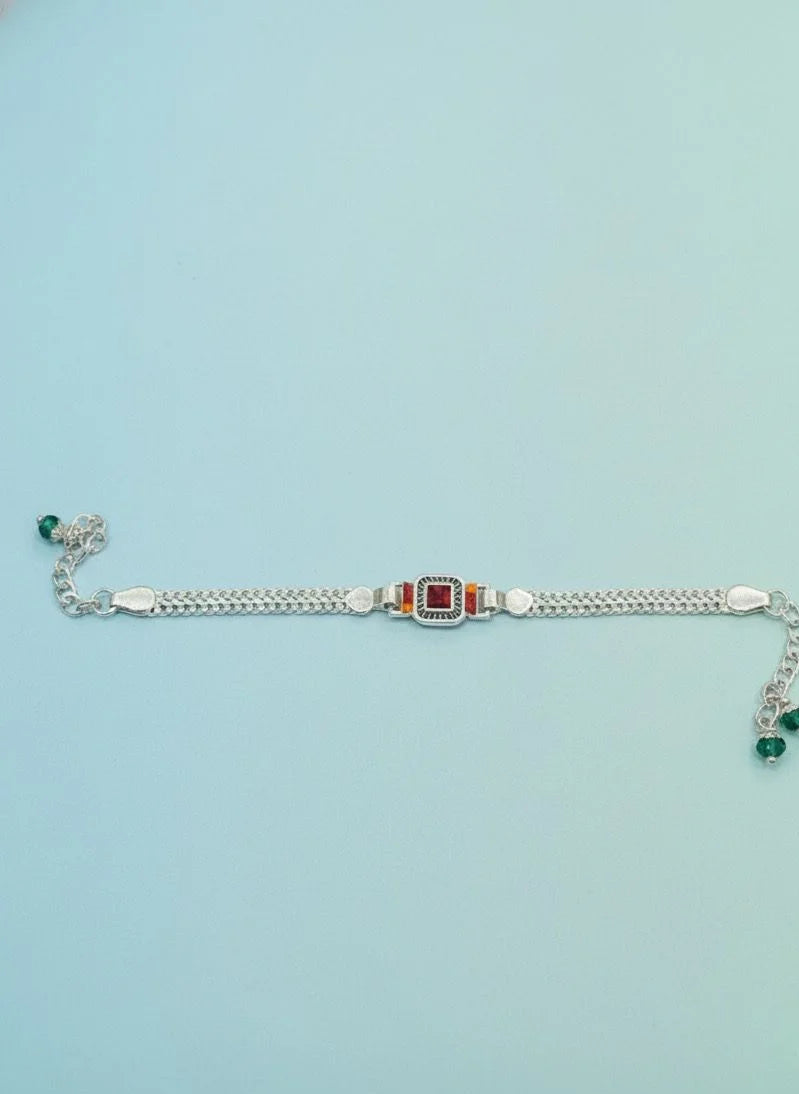 Silver bracelet with gemstones on a light blue background