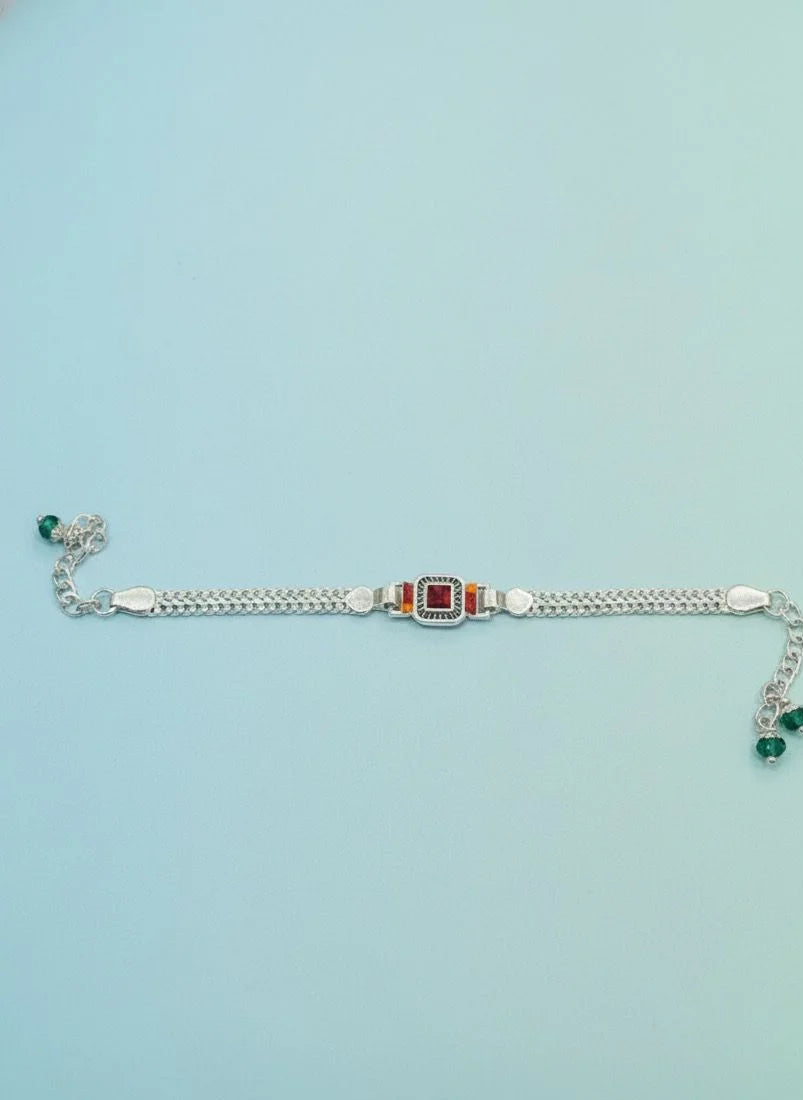 Silver bracelet with gemstones on a light blue background