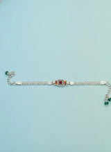 Silver bracelet with gemstones on a light blue background