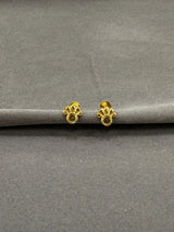 Gold earrings on a gray surface