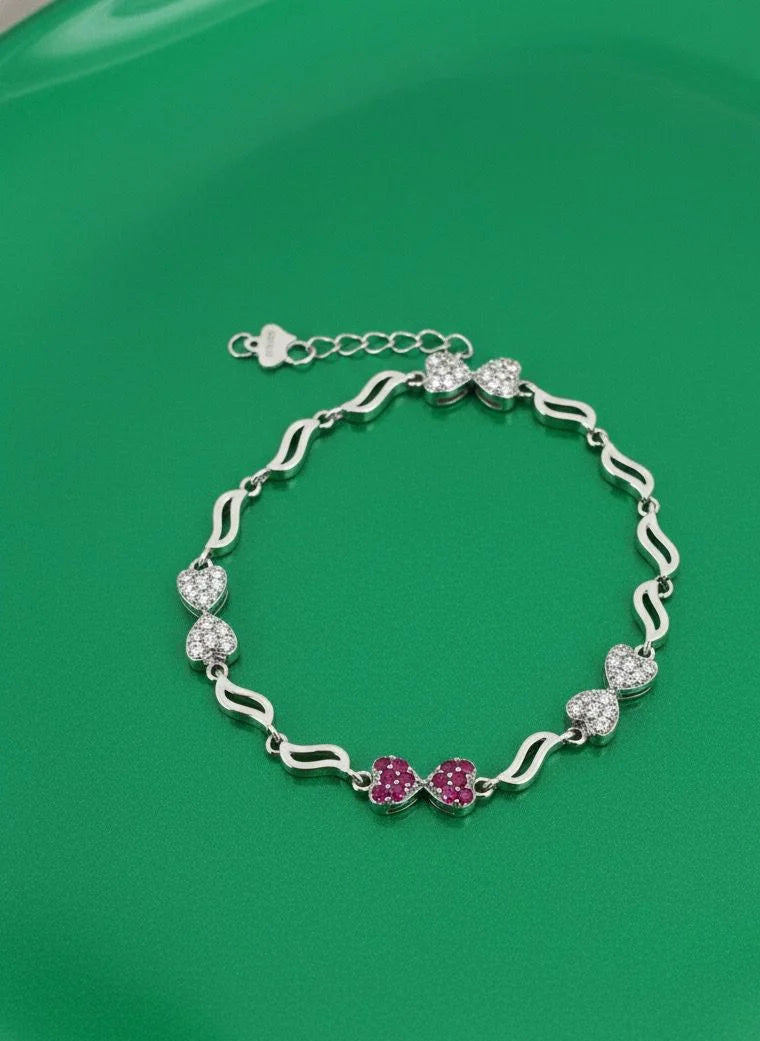 Silver bracelet with pink flowers on a green background