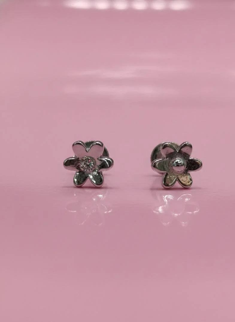 Flower-shaped earrings on a pink background