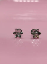 Flower-shaped earrings on a pink background