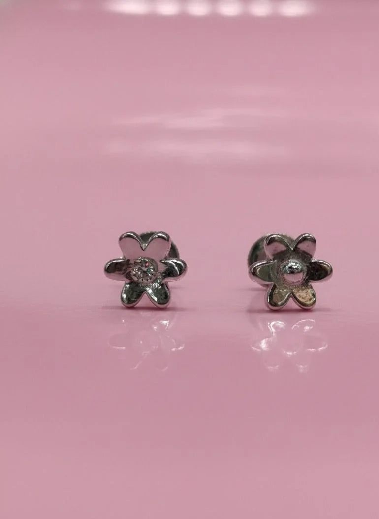 Flower-shaped earrings on a pink background