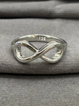 Silver infinity ring on a gray fabric background