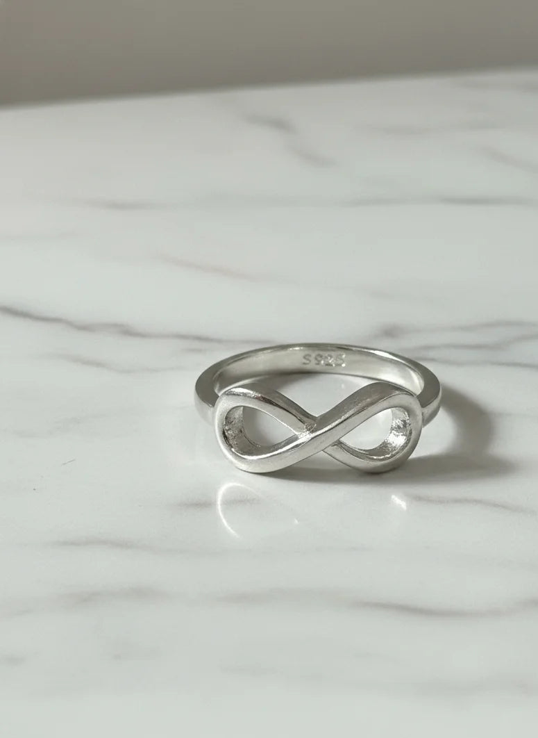 Silver infinity ring on a marble surface