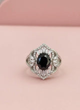 Elegant ring with a black gemstone on a pink background