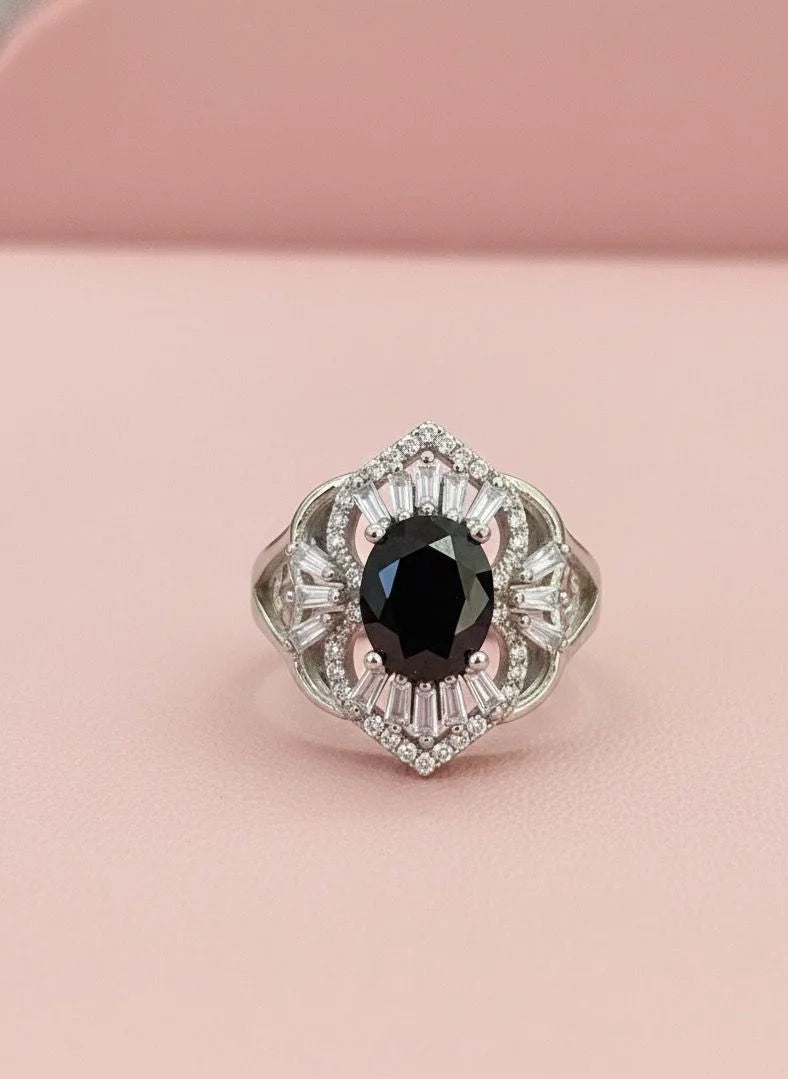 Elegant ring with a black gemstone on a pink background