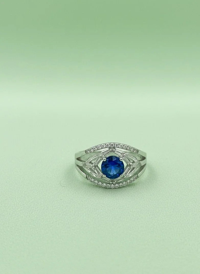 Silver ring with a blue gemstone on a light green background