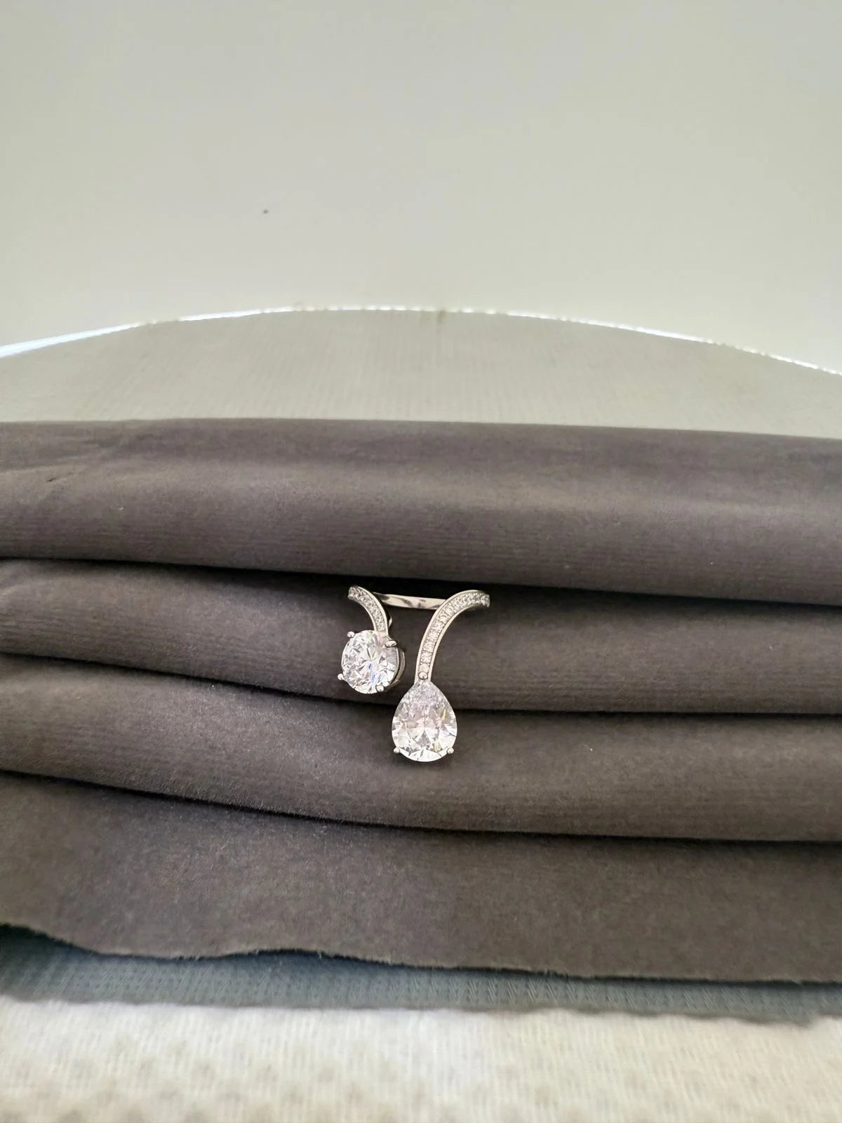 Pair of diamond finish rings on a gray fabric surface