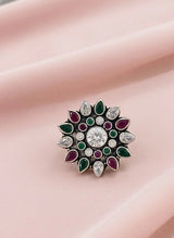 Decorative ring with gemstones on a pink fabric background