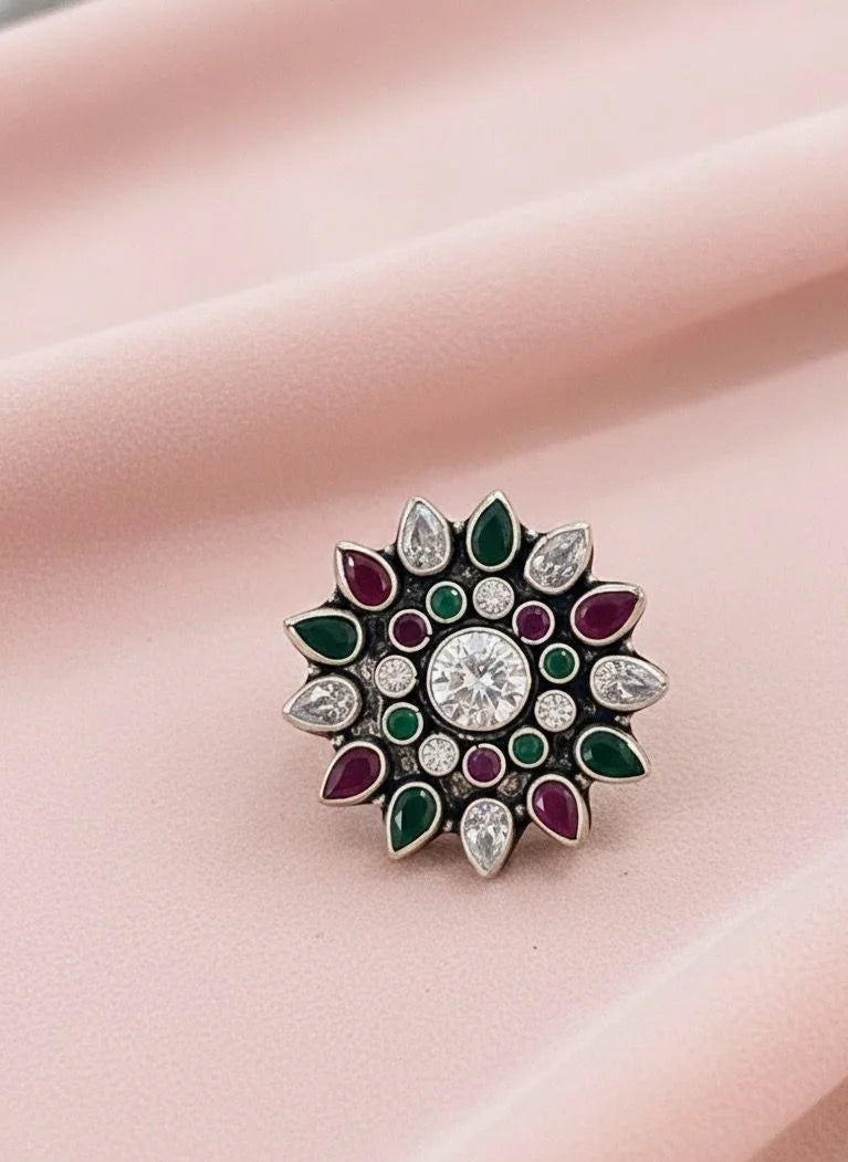 Decorative ring with gemstones on a pink fabric background