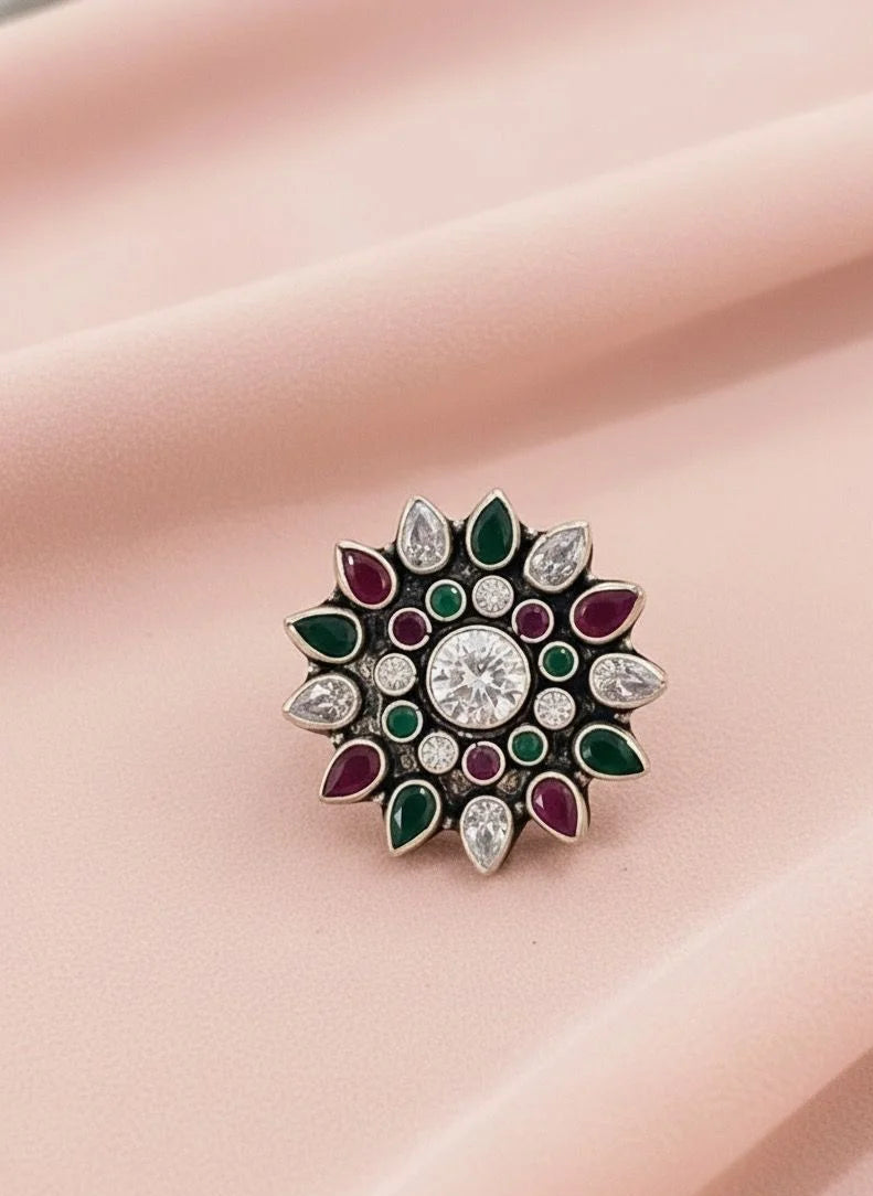 Decorative ring  with gemstones on a pink fabric background