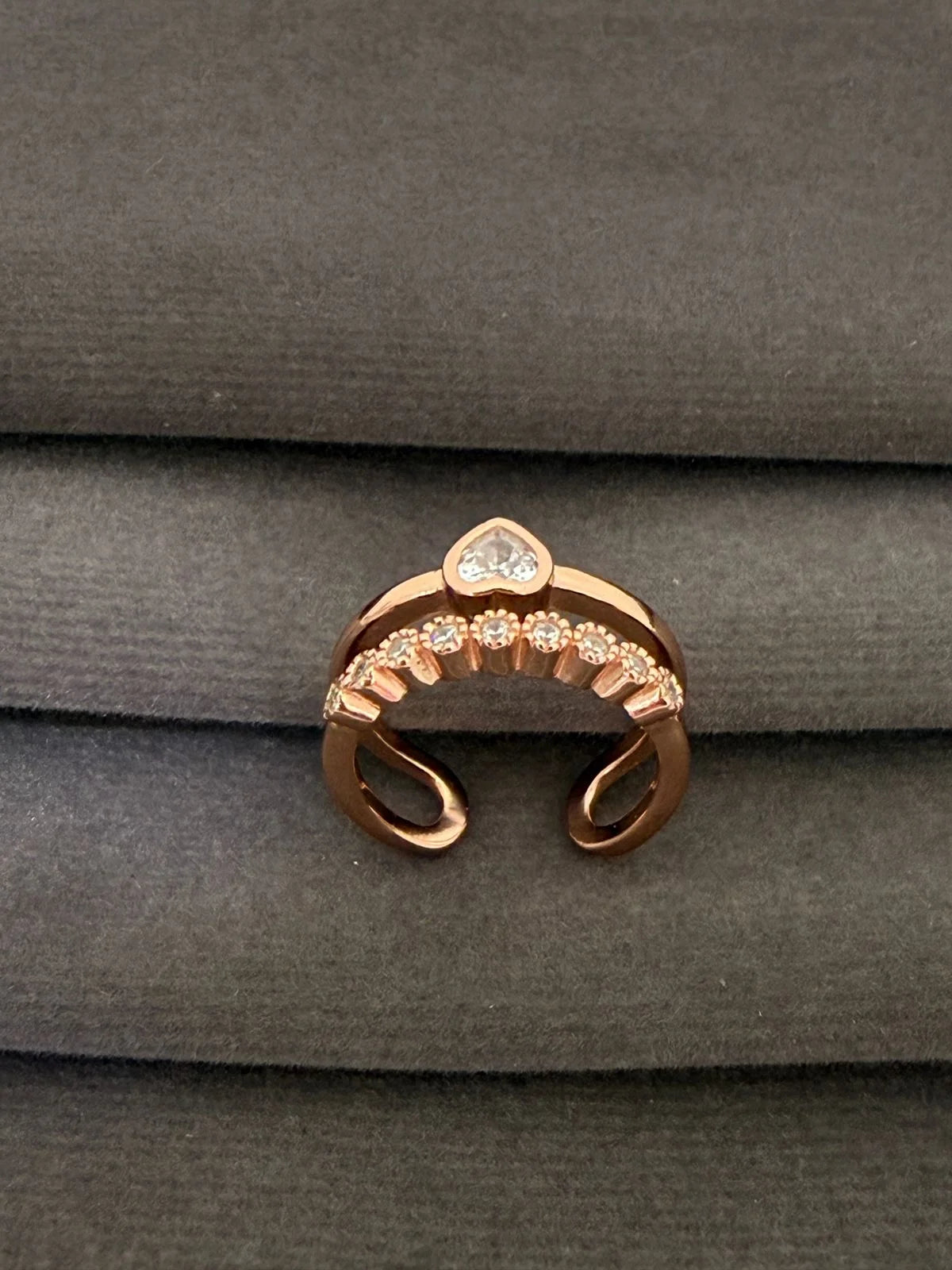 Rose gold ring with gemstones on a gray fabric background