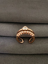 Rose gold ring with gemstones on a gray fabric background