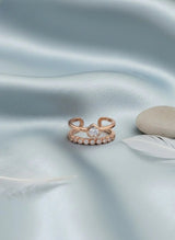 Rose gold ring with stone on a light blue satin surface