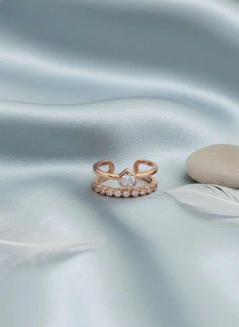 Rose gold ring with stone on a light blue satin surface