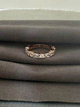 Rose gold ring with diamonds on a gray fabric background