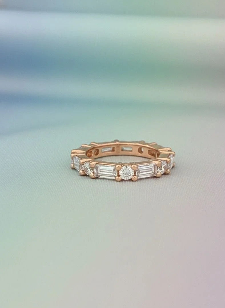 Rose gold ring with diamonds on a gradient background