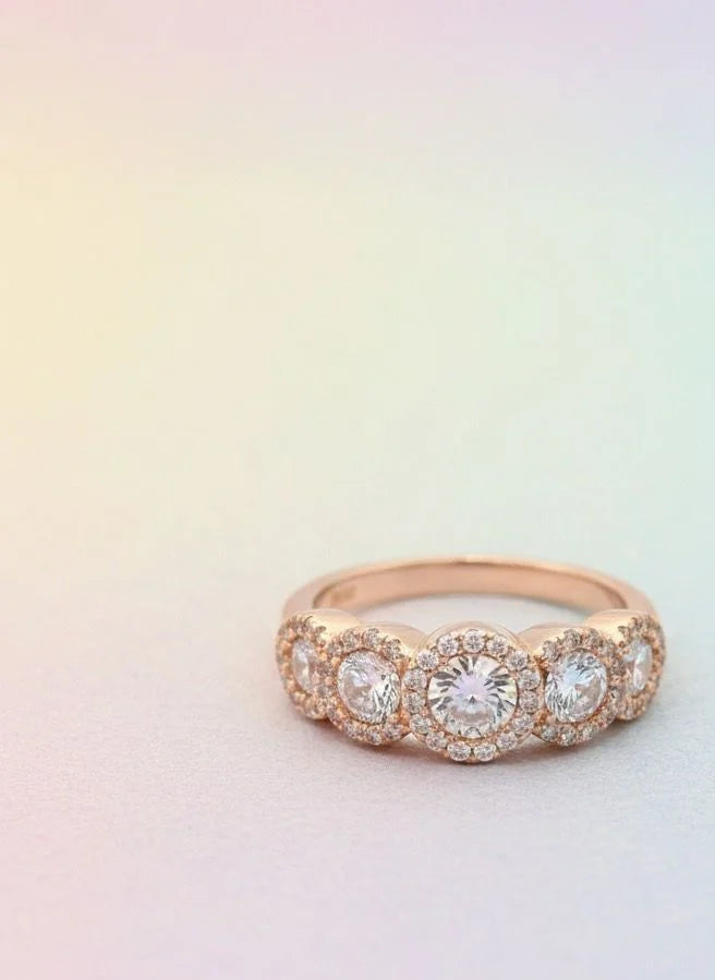 Rose gold ring with diamonds on a gradient background