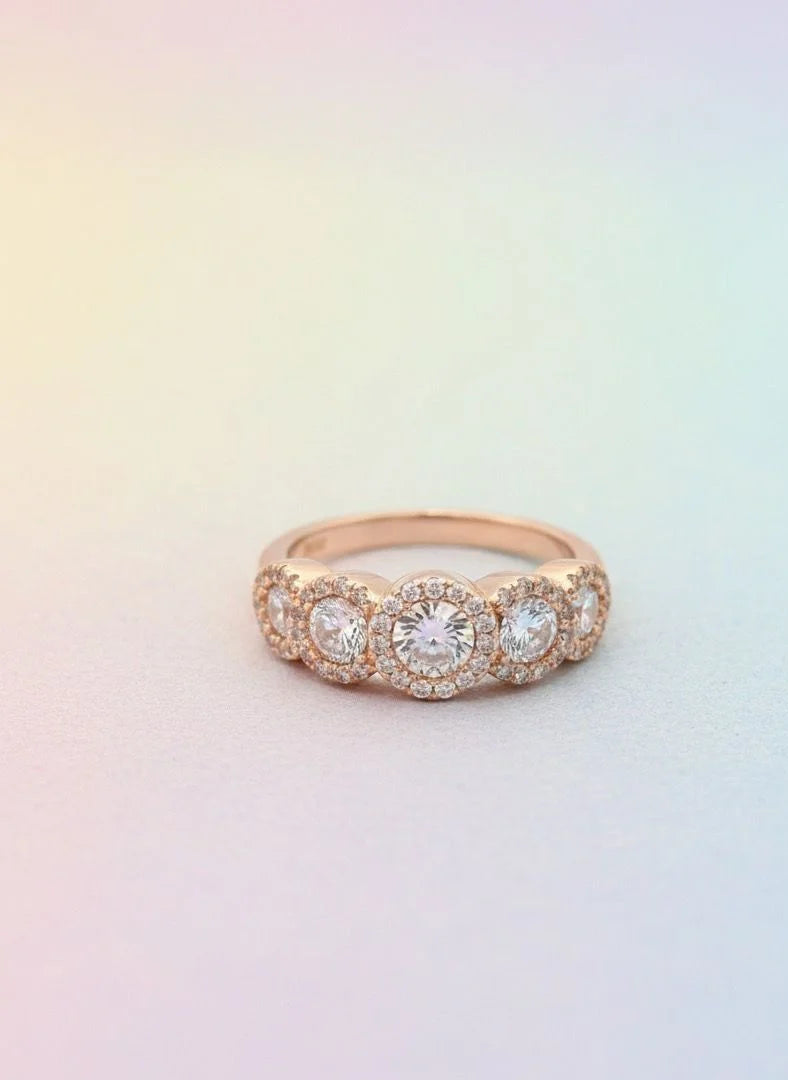 Rose gold ring with diamonds on a gradient background
