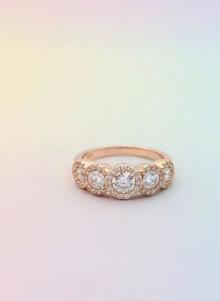 Rose gold ring with diamonds on a gradient background