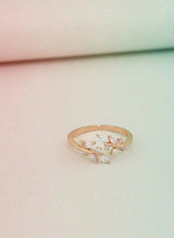 Rose gold ring with diamond accents on a light pink background