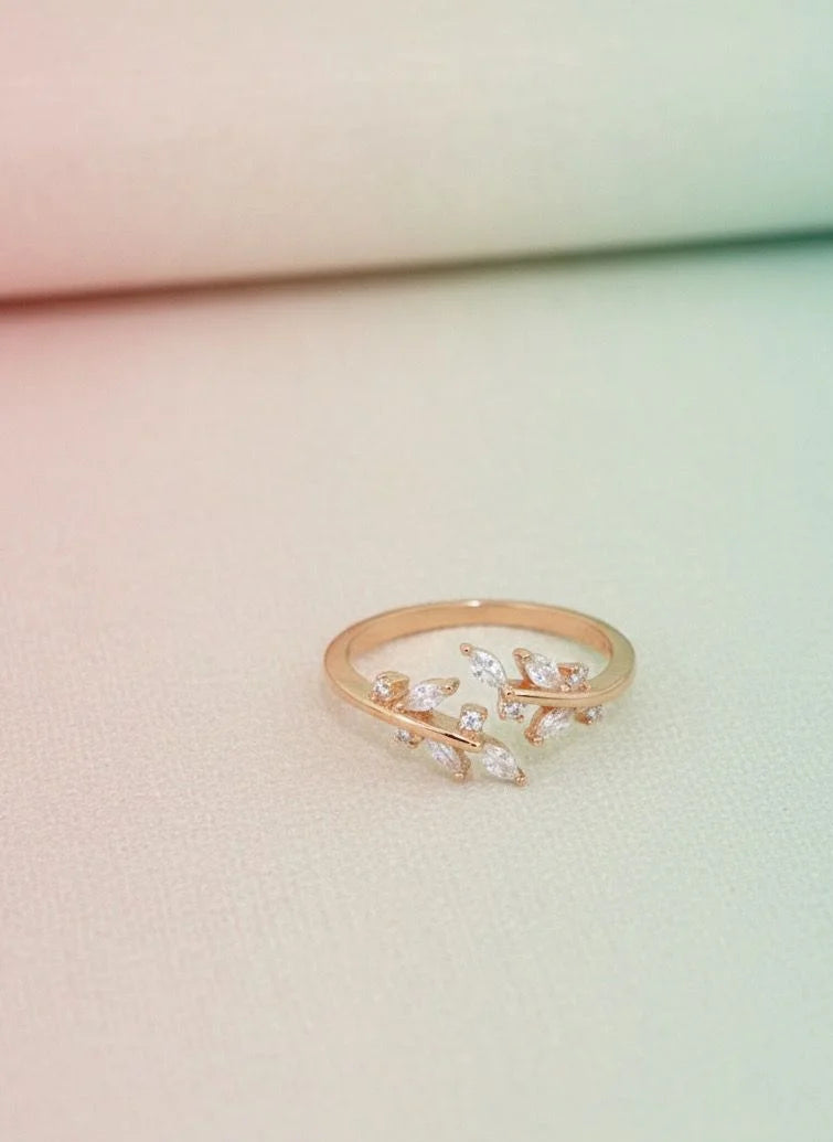 Rose gold ring with diamond accents on a light pink background
