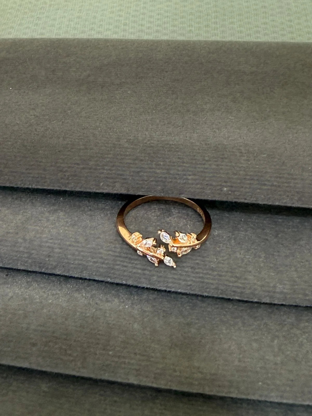 Gold ring with gemstones on a green fabric background