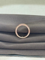Rose gold ring with small stones on a gray fabric background