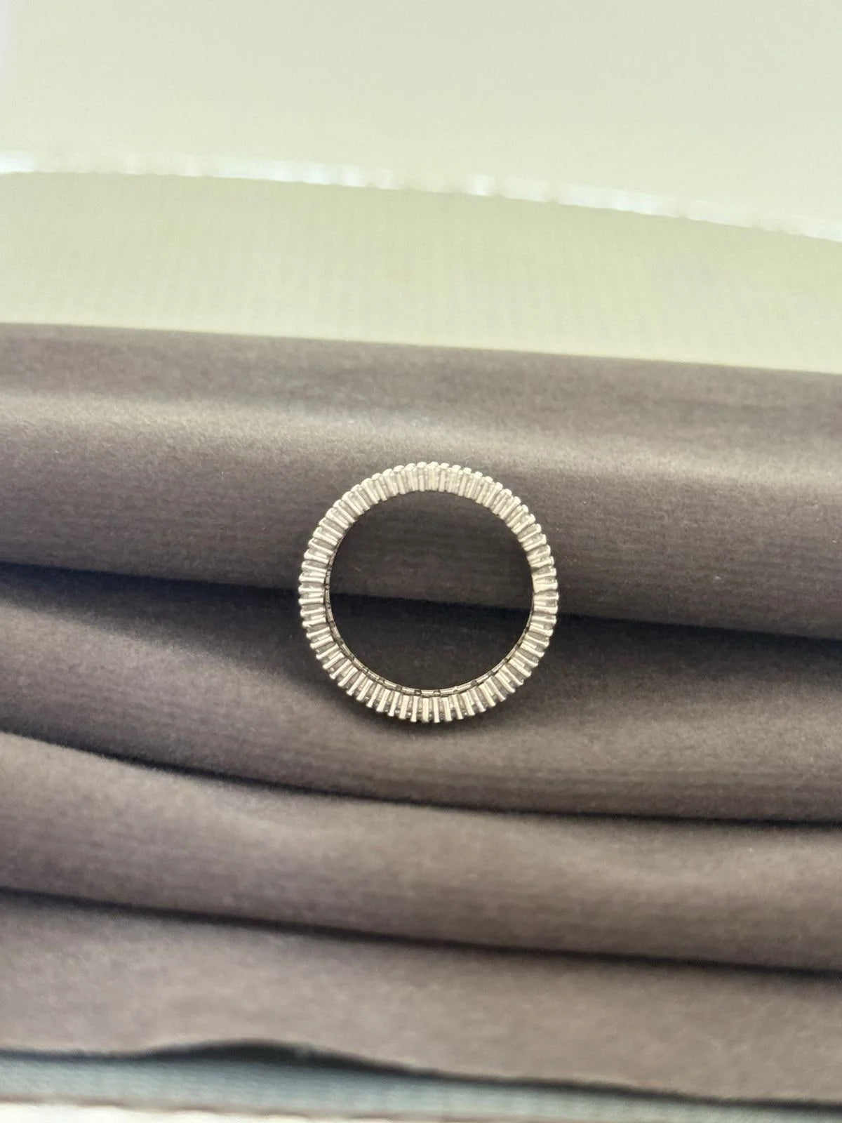 Silver ring on a stack of gray fabric
