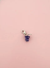 Cool drink charm with blue frosting on a pink background