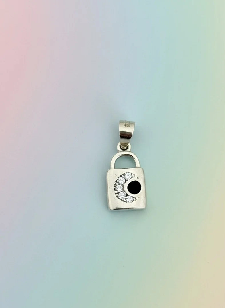 Silver padlock-shaped pendant with a black center and clear stones on a gradient background