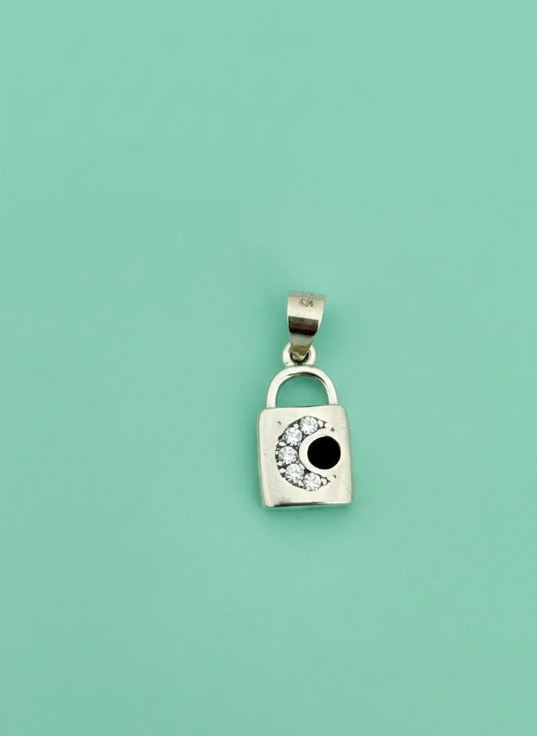 Silver padlock-shaped pendant with a black center on a light green background