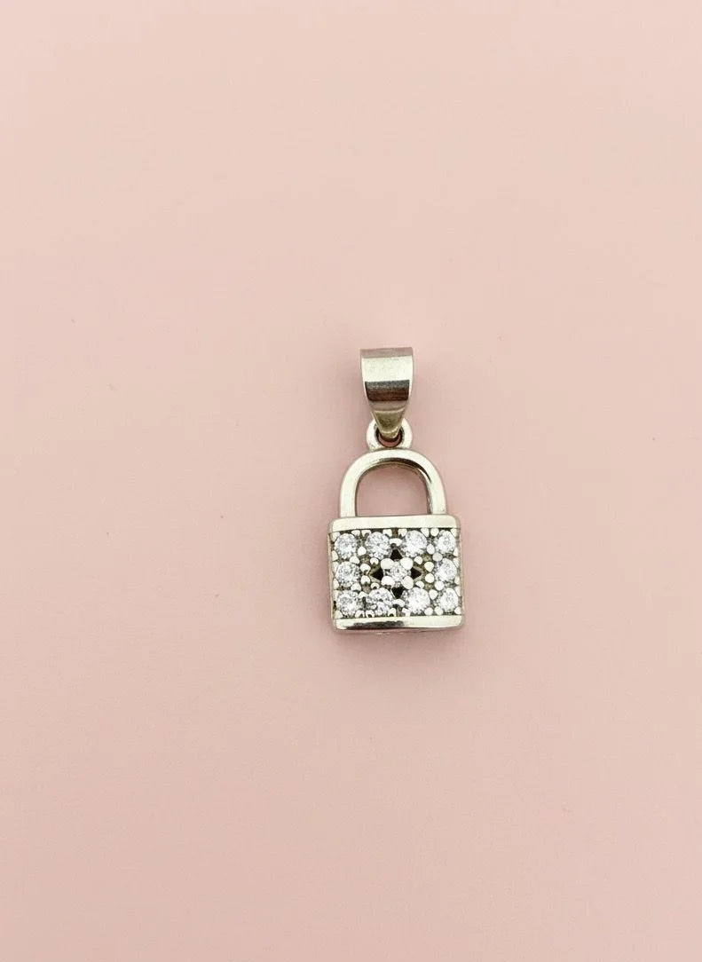 Silver padlock-shaped pendant with clear stones on a pink background