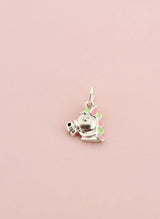 Silver charm of a cat with a flower on a pink background
