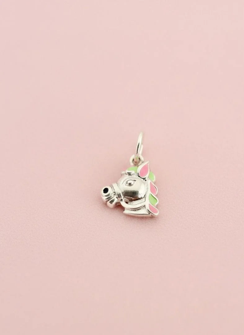 Silver charm of a cat with a flower on a pink background