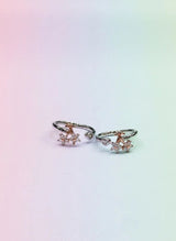 Pair of toe rings with floral designs on a gradient background